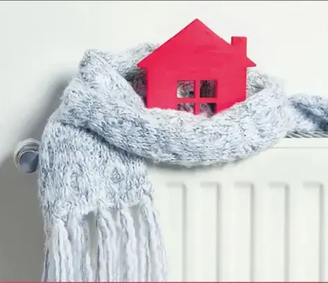 rött hus med en grå skarf surrat runt sig, som står på en radiator